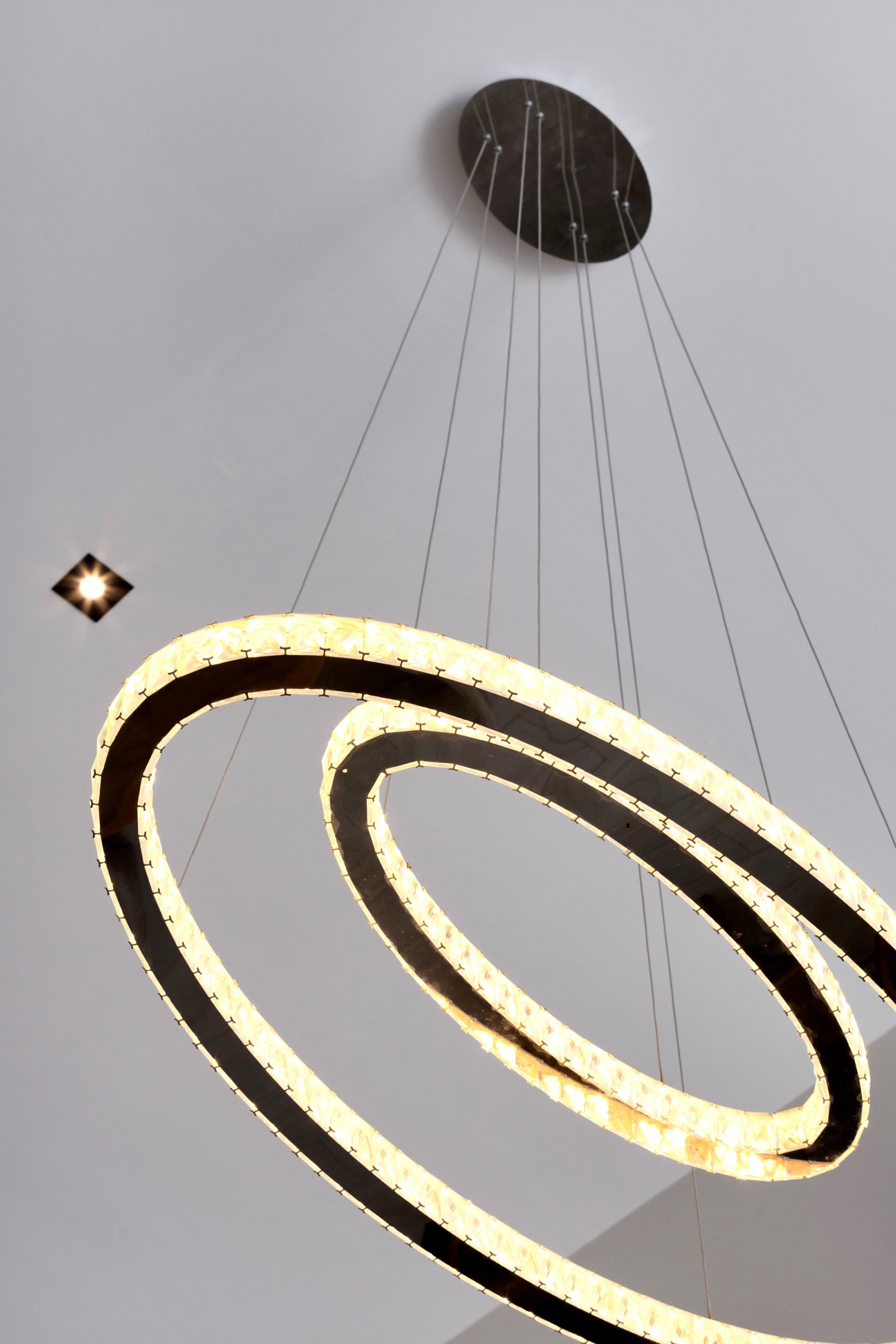 Luxury Bonaire villa interior detail of a modern spiral chandelier with glowing alabaster in a high-ceiling living space.